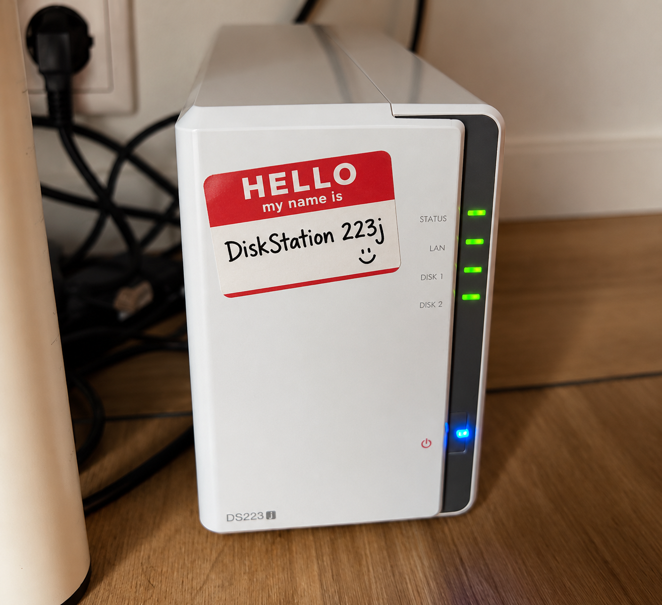 Schale the white Synology DiskStation under a desk with a Hello my name is DiskStation 223j sticker